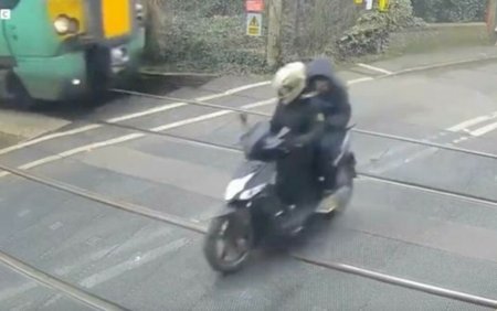 VIDEO | Momentul in care un <span style='background:#EDF514'>SCUTER</span>ist trece prin fata unui tren. Barbatul avea in spate un pasager
