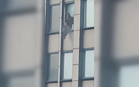 Un barbat cautat de FBI a stat ore intregi agatat de un geam de la etajul 30 amenintand ca se sinucide