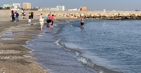 Nebunie pe <span style='background:#EDF514'>LITORALUL ROMANESC</span>: plaja e plina, oamenii se scalda in mare. Apa este ca in luna iulie! VIDEO