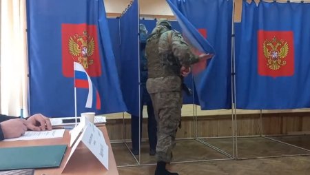 Un soldat rus cu mitraliera si cagula e filmat cand intra peste alegatori in cabina, sa verifice cum au votat la alegerile prezidentiale