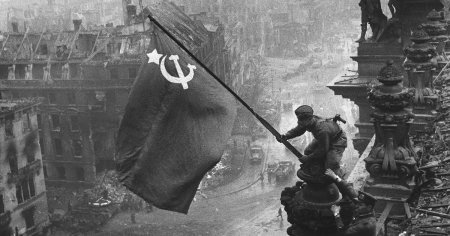 Imaginea emblematica a caderii Berlinului: un rus, cu doua ceasuri la mana, ridica steagul Armatei Rosii deasupra Reichstag-ului VIDEO